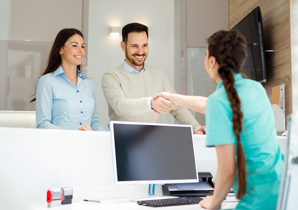 Couple meeting dental receptionist