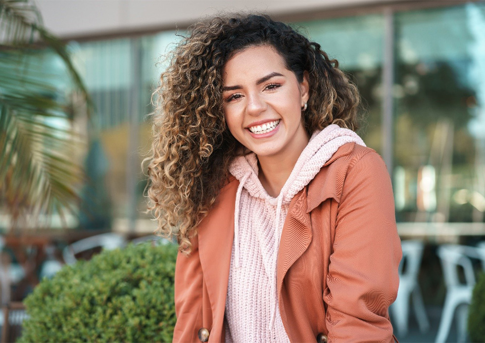 Smiling woman in a pink sweater and orange jacket
