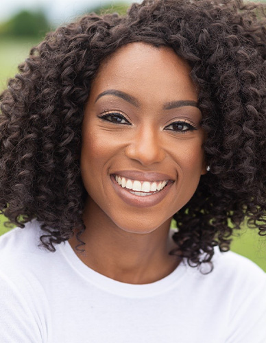 Woman smiling outdoors with flawless teeth