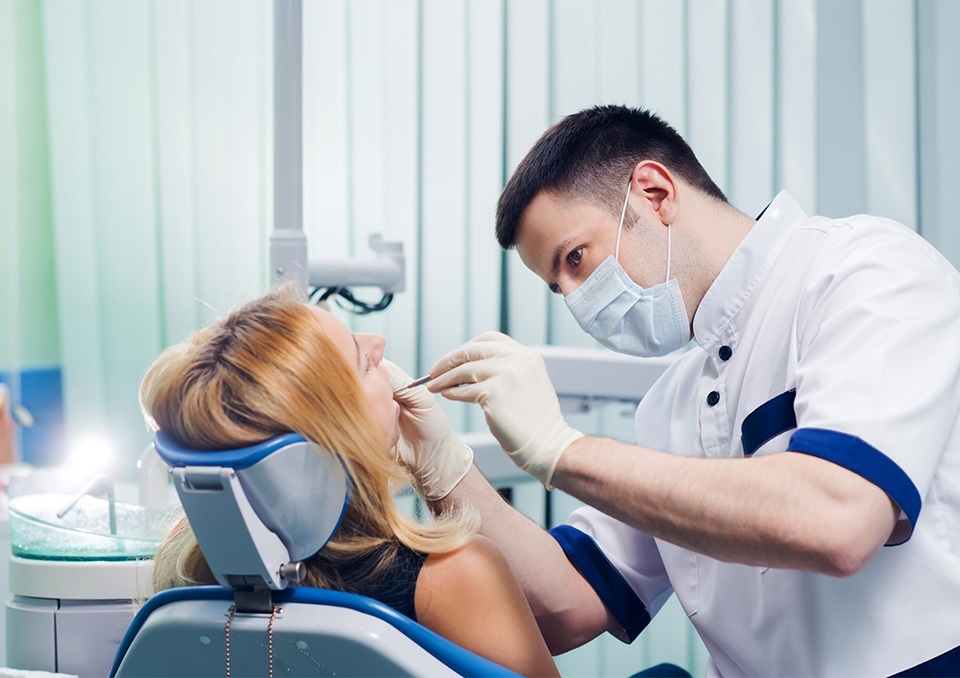 Cosmetic dentist examining a patients teeth