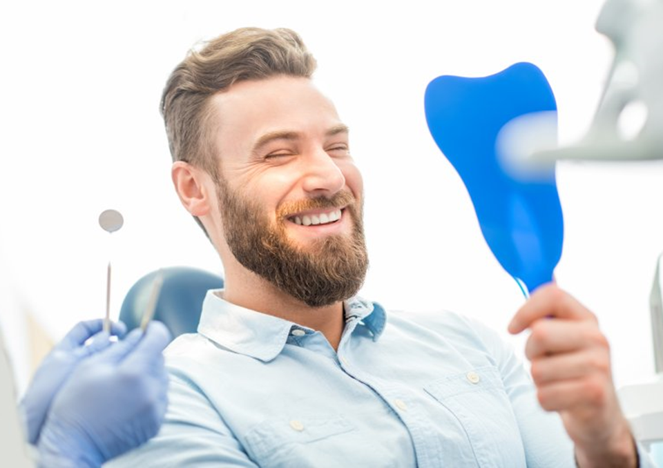 a patient smiling after receiving his dental bridge in Richardson