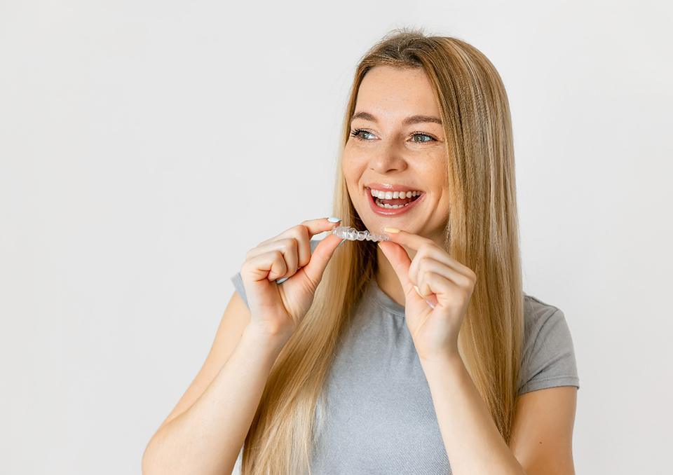 Smiling woman placing Candid clear aligner tray
