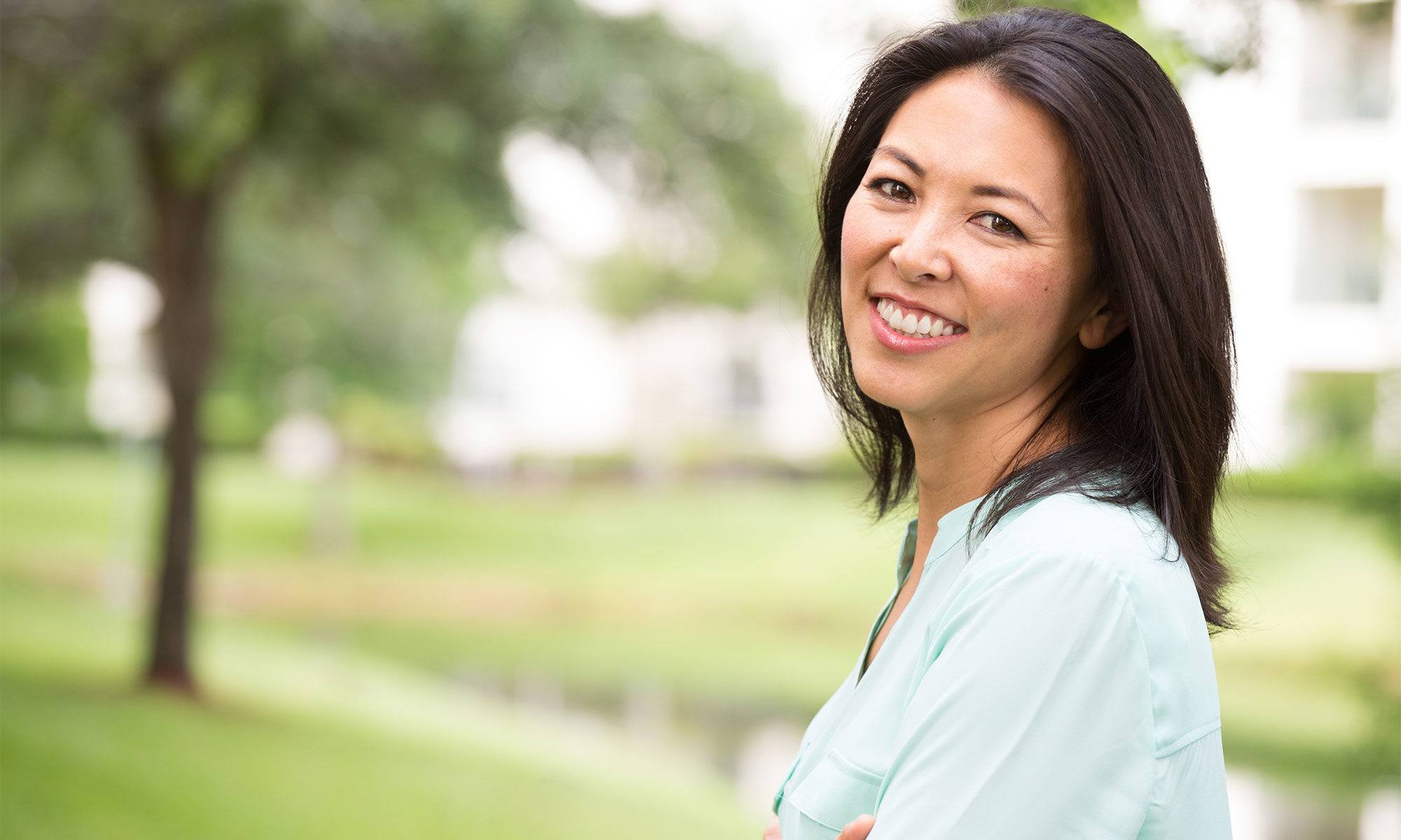 Woman sharing flawless smile thanks to dental crowns and bridges