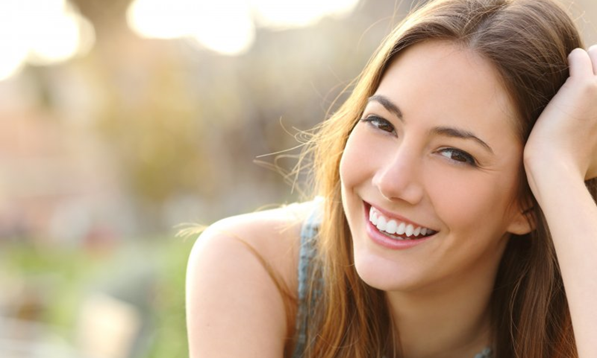 a woman smiling after receiving dental crowns in Richardson