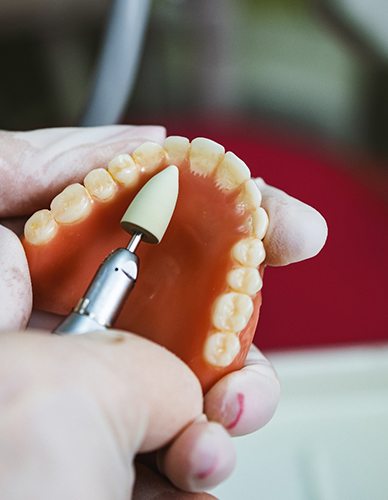 Lab tech filing dentures