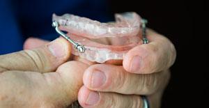 Dentist holding a denture