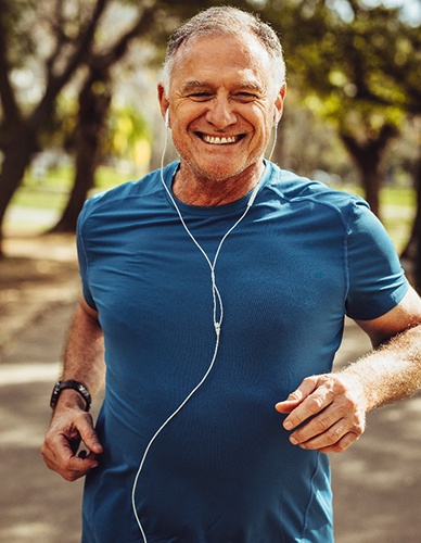 Man smiling while jogging outside