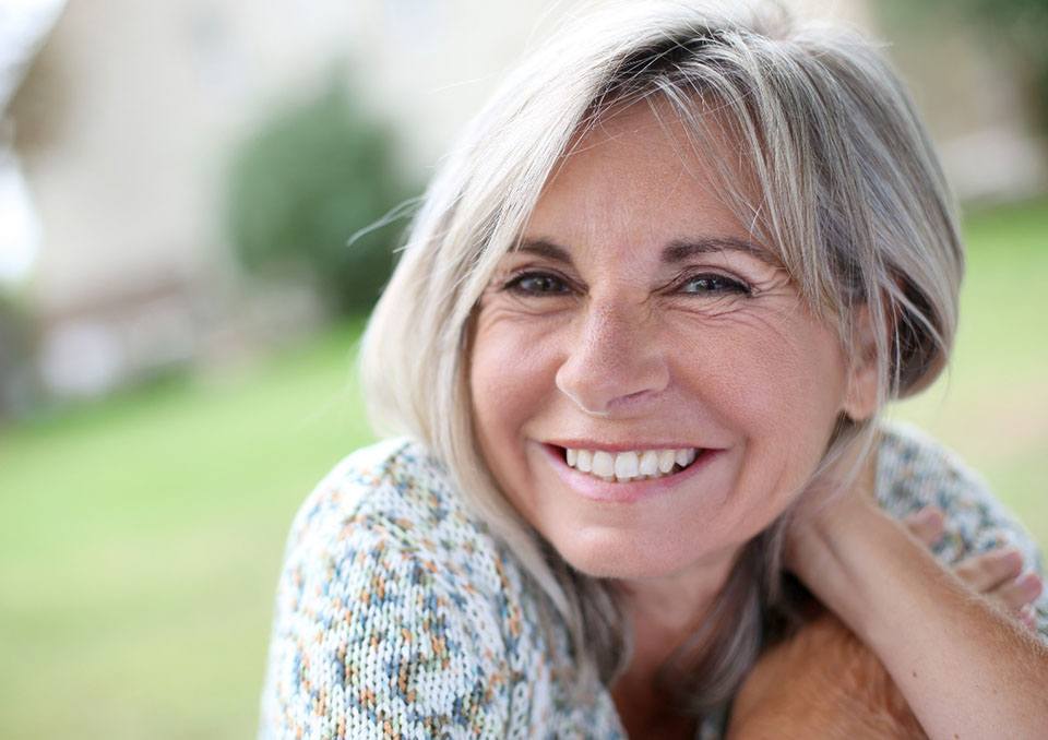 Senior woman in sweater with implant dentures in Richardson, TX