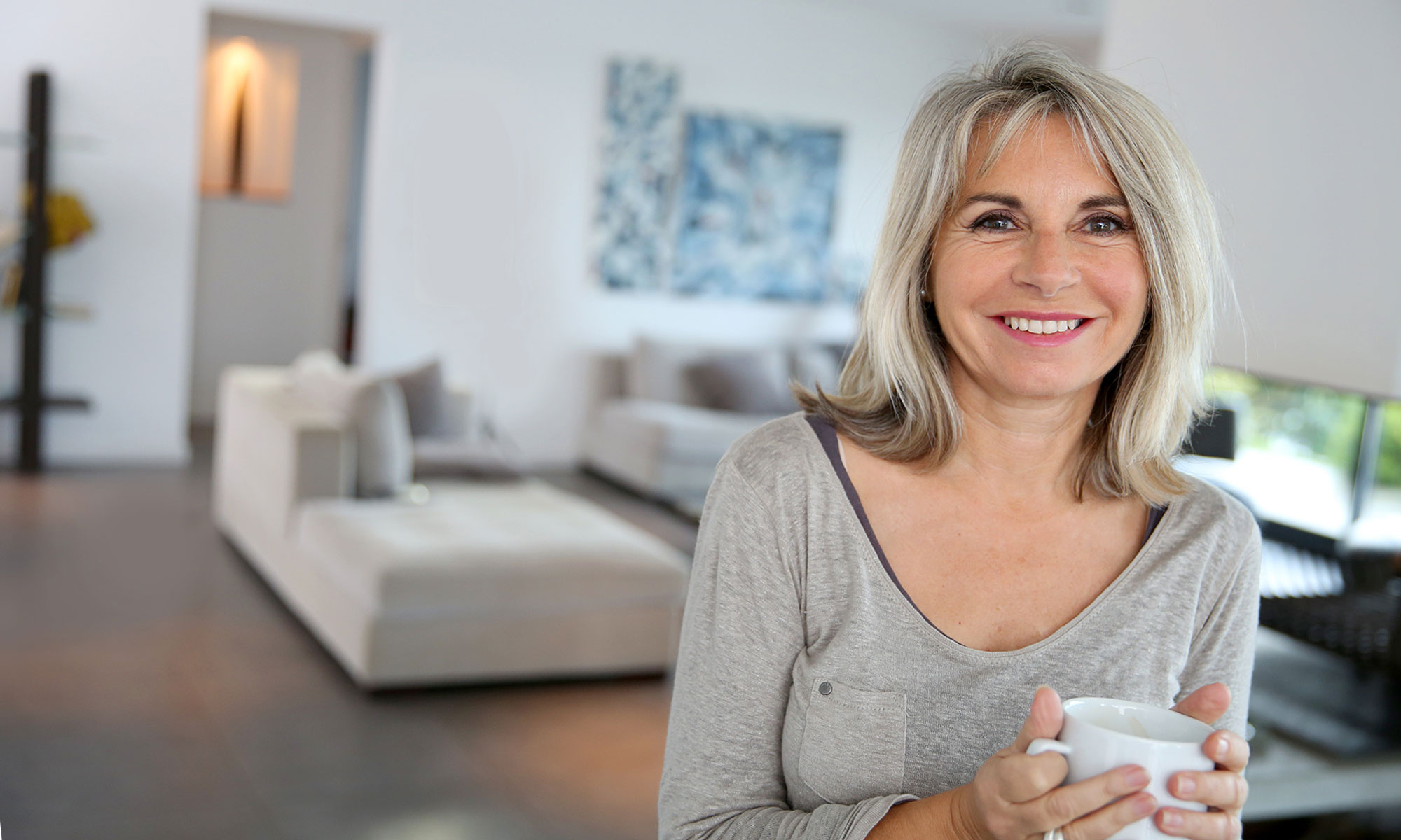 Woman sharing flawless smile after tooth replacement with dental implants