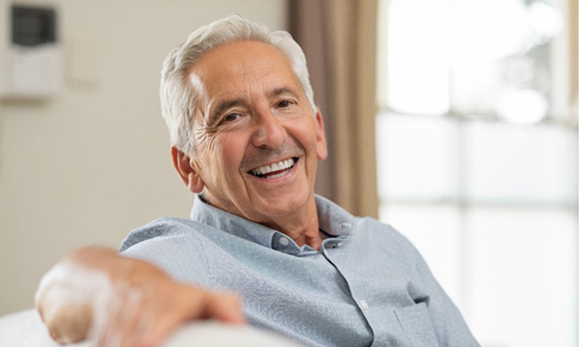 man smiling while sitting on couch 