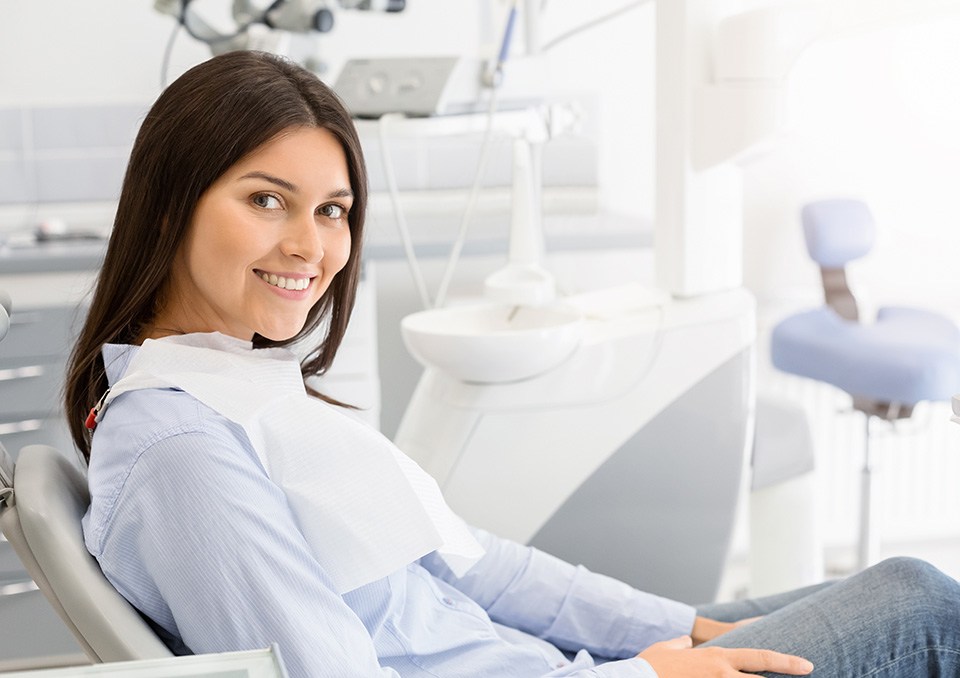 Woman leaning back in dental chair and smiling