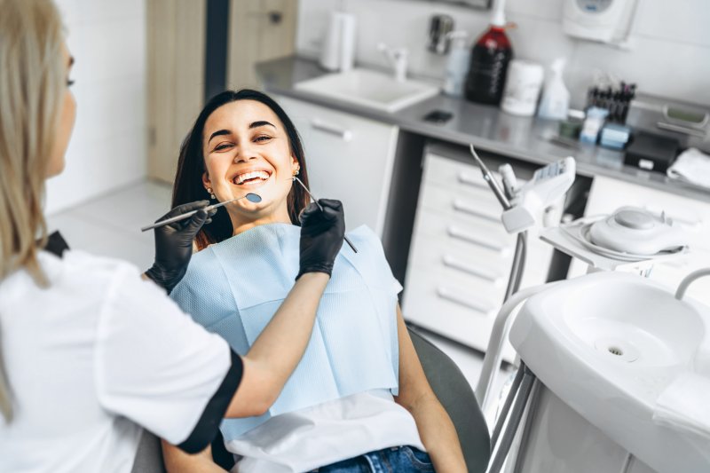 Dentist working on smiling patient’s cosmetic dentistry