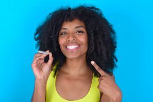 woman holding Invisalign aligner