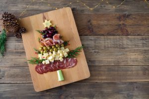 Charcuterie organized to look like a Christmas tree on a wooden background