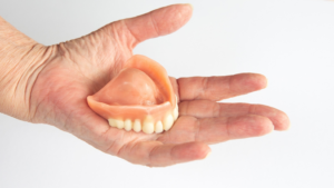a patient holding their dentures
