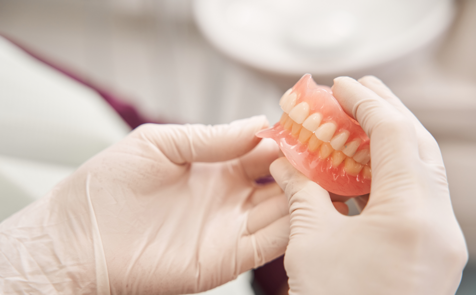 Dentist holding dentures